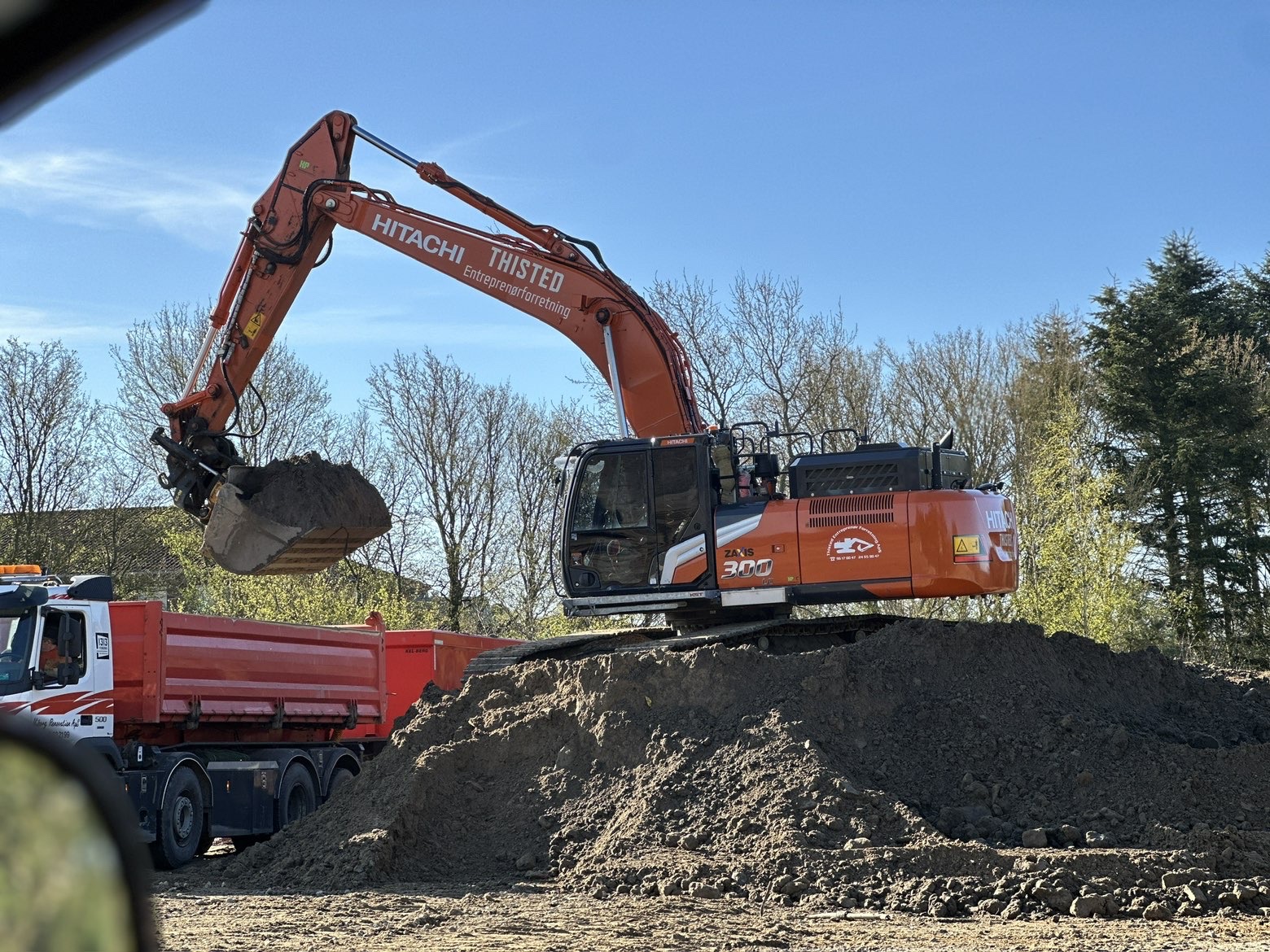 Gravemaskine i arbejde på jordbunke